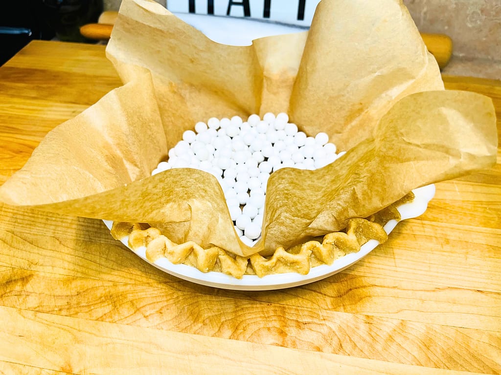 fresh milled flour pie crust with parchment paper and pie weights