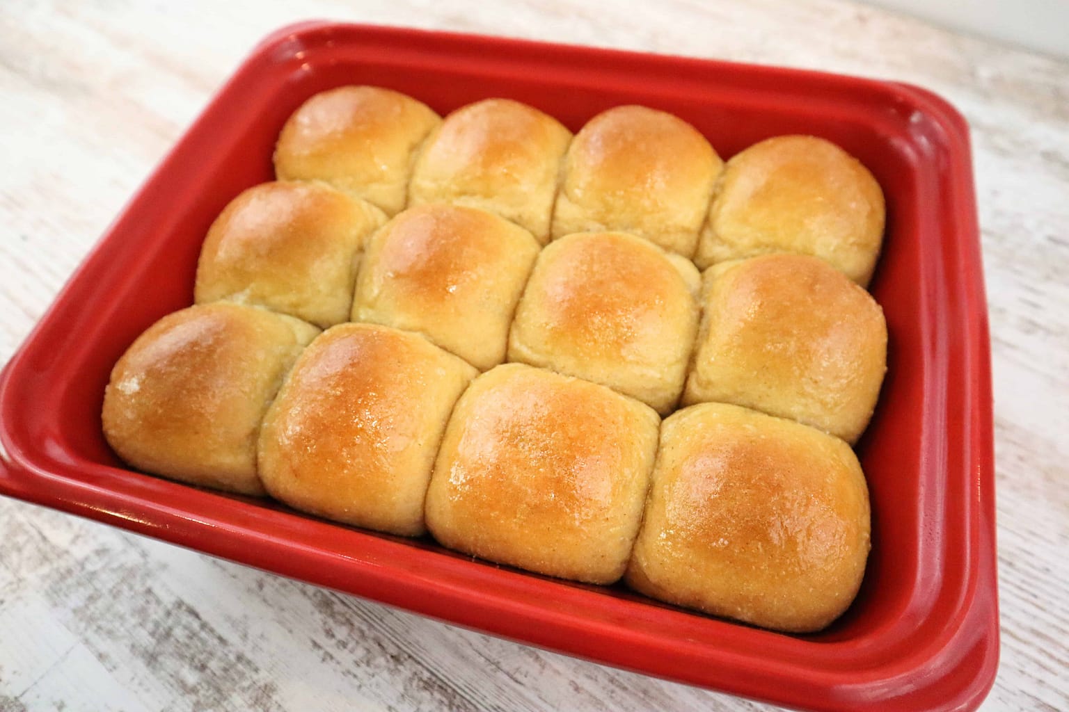 Soft, freshly baked rolls in a red skillet, perfect for breakfast or dinner.