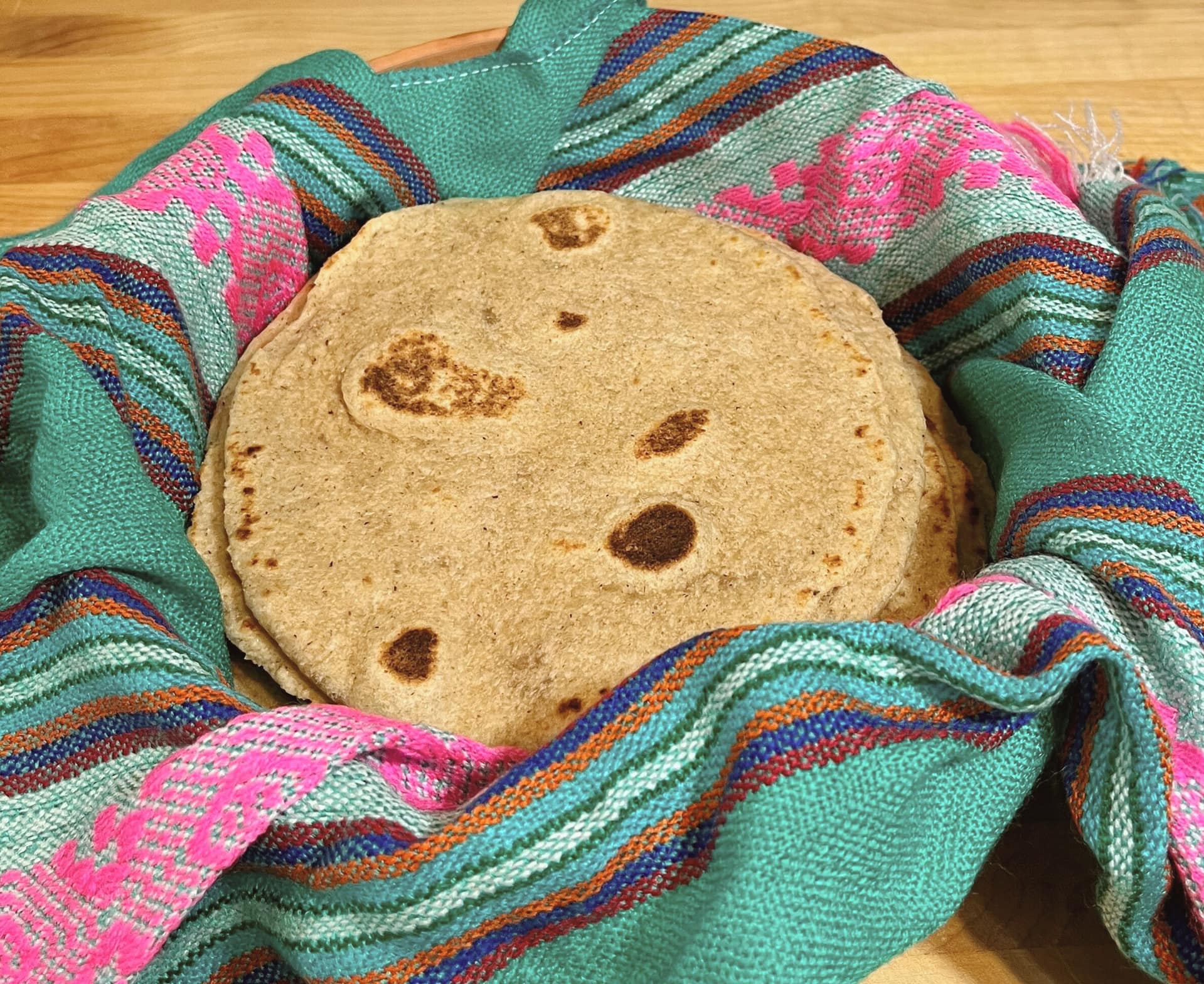 soft fresh milled flour tortillas in colorful towel.