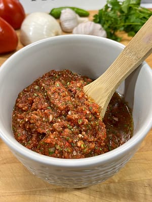 fresh salsa in bowl with wooden spoon