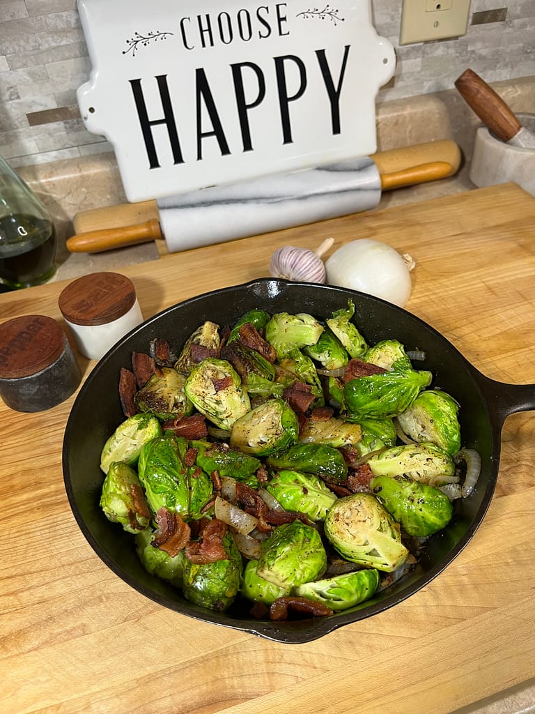 brussels sprouts in cast iron skillet with choose happy sign